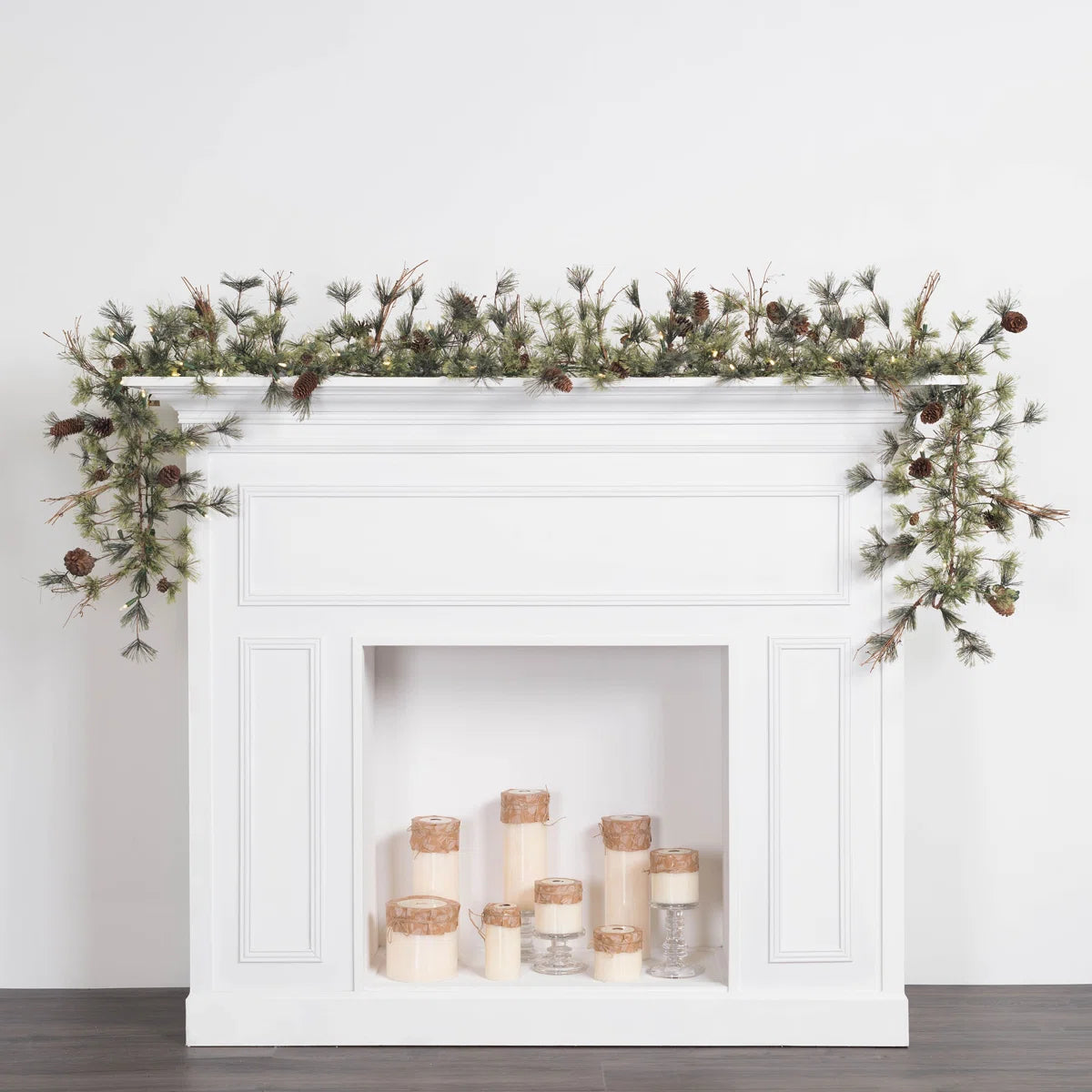 Dakota frosted pine garland lit on a white fireplace mantel