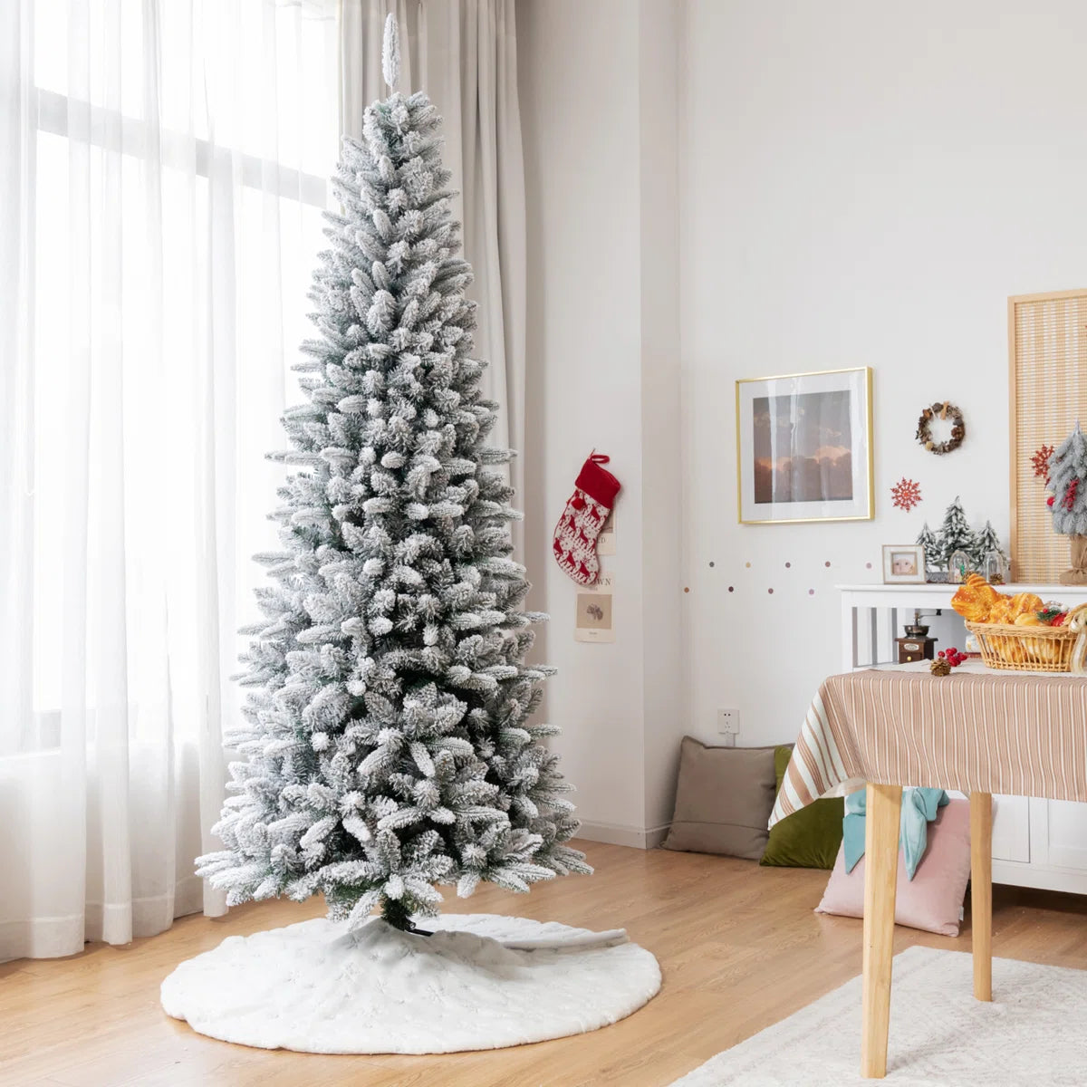 Slender white flocked Christmas tree in a bright dining room