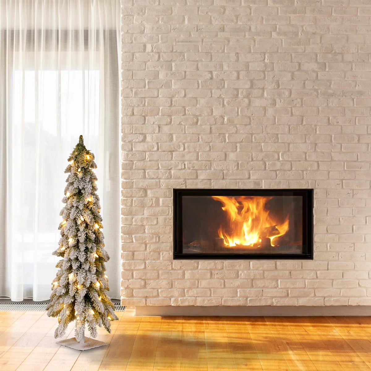 Small snowy Christmas tree next to a fireplace