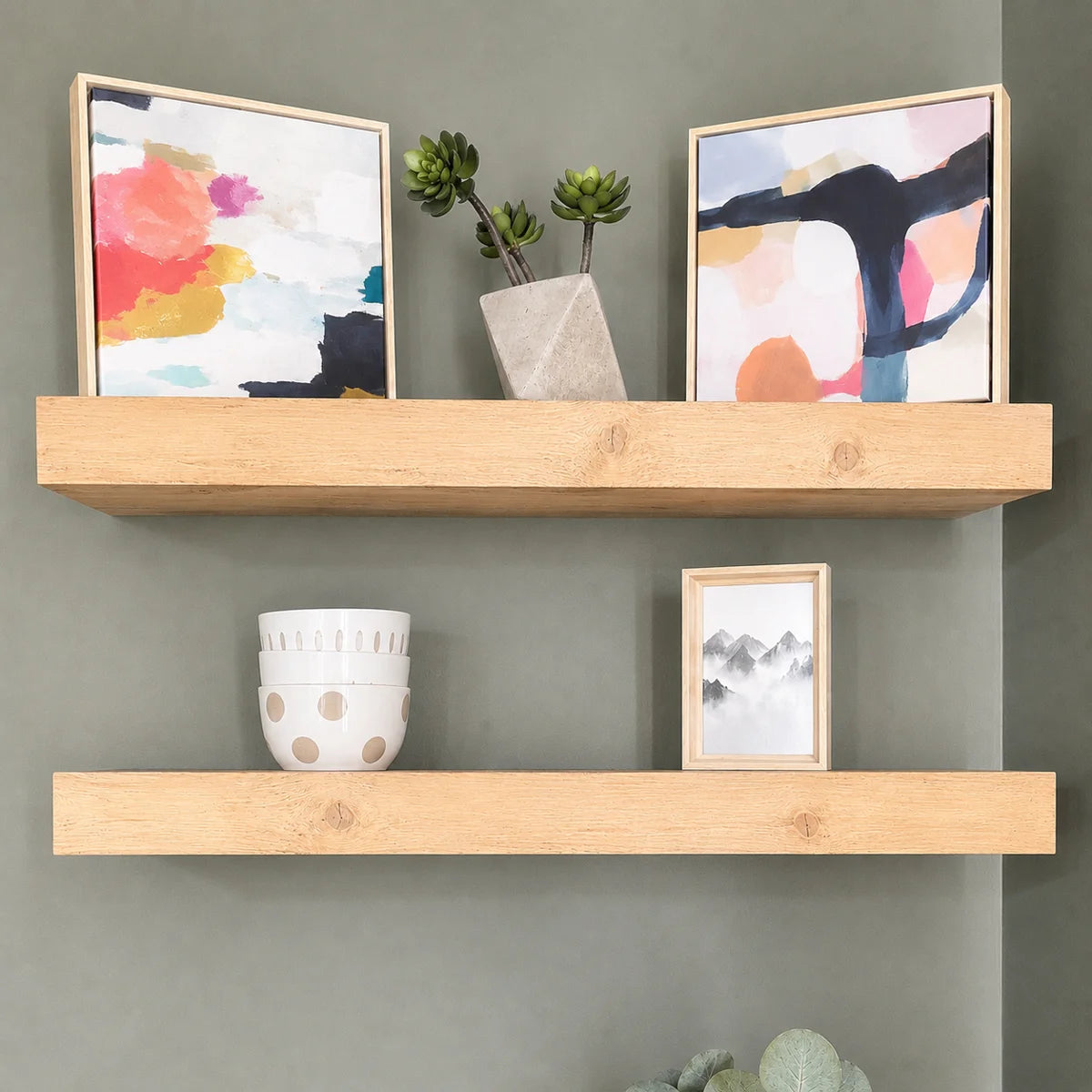 Arzhin shelves styled with art prints on a sage wall