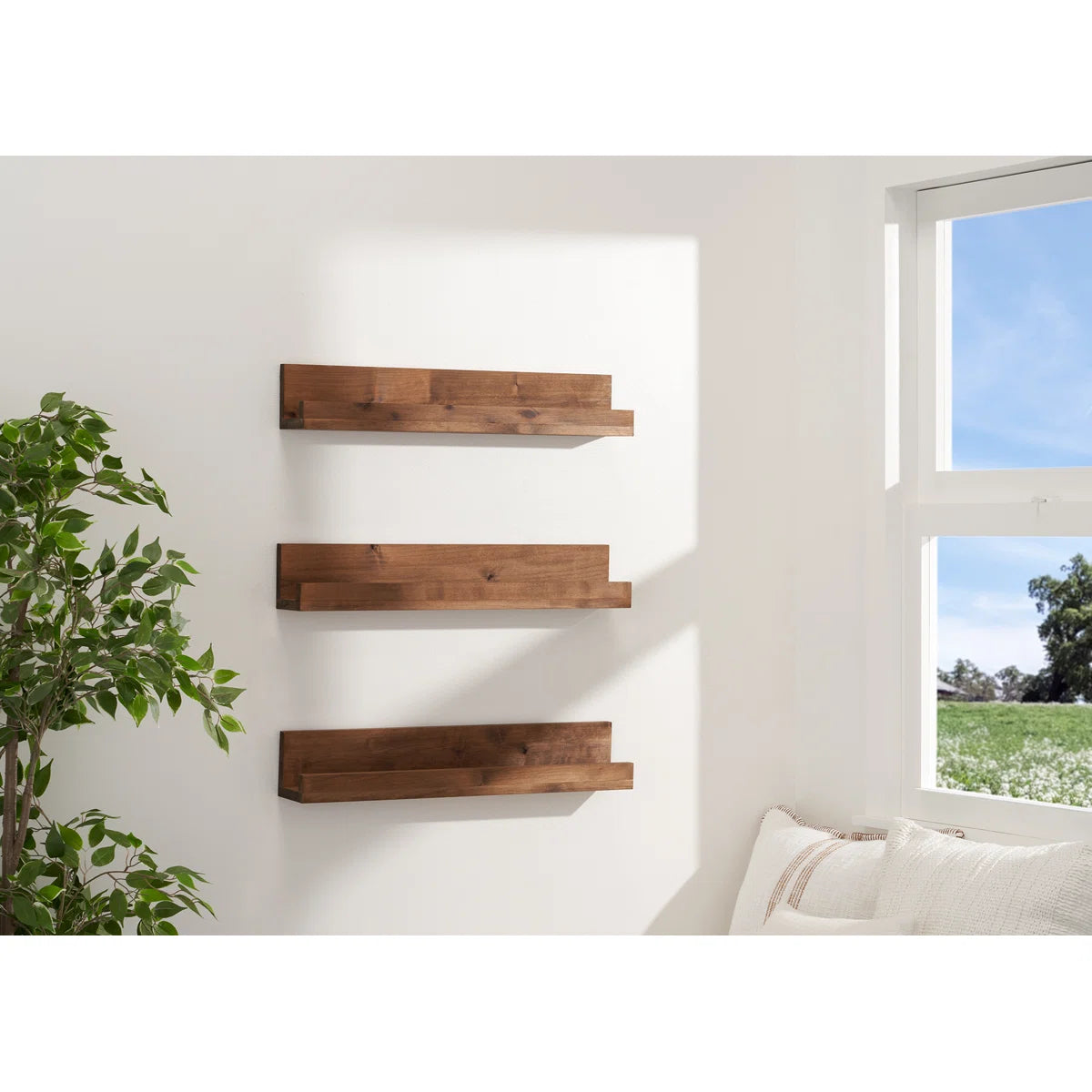 Drakestone wood ledge shelves with framed prints by a window