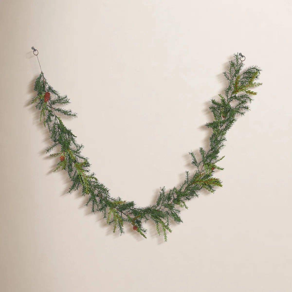 Hemlock pine garland draped on a warm wall