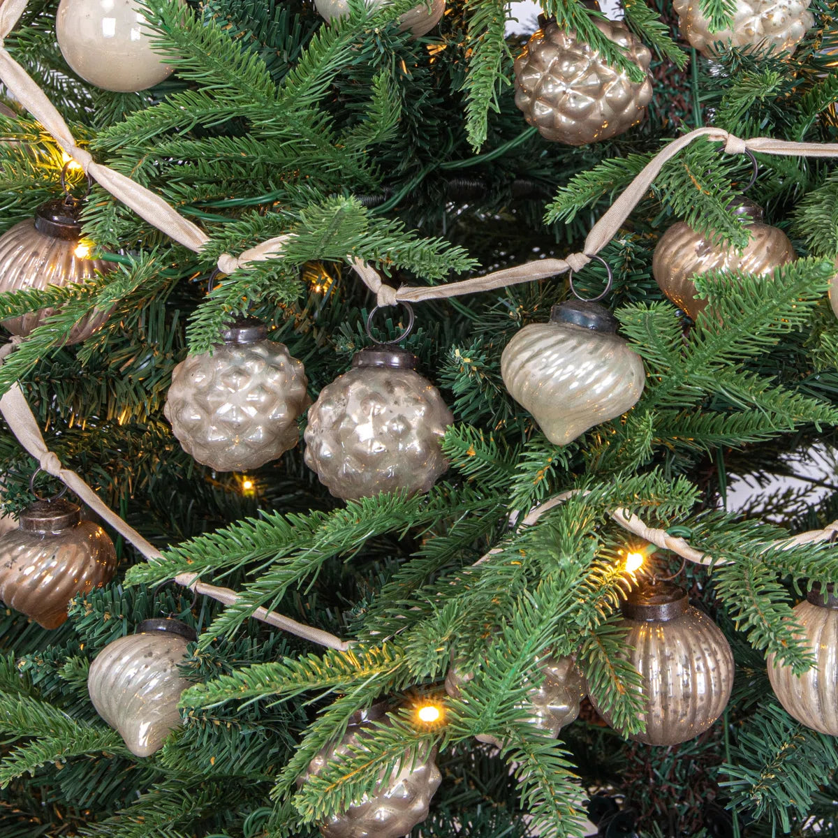 Ornament garland on a Christmas tree with warm lights