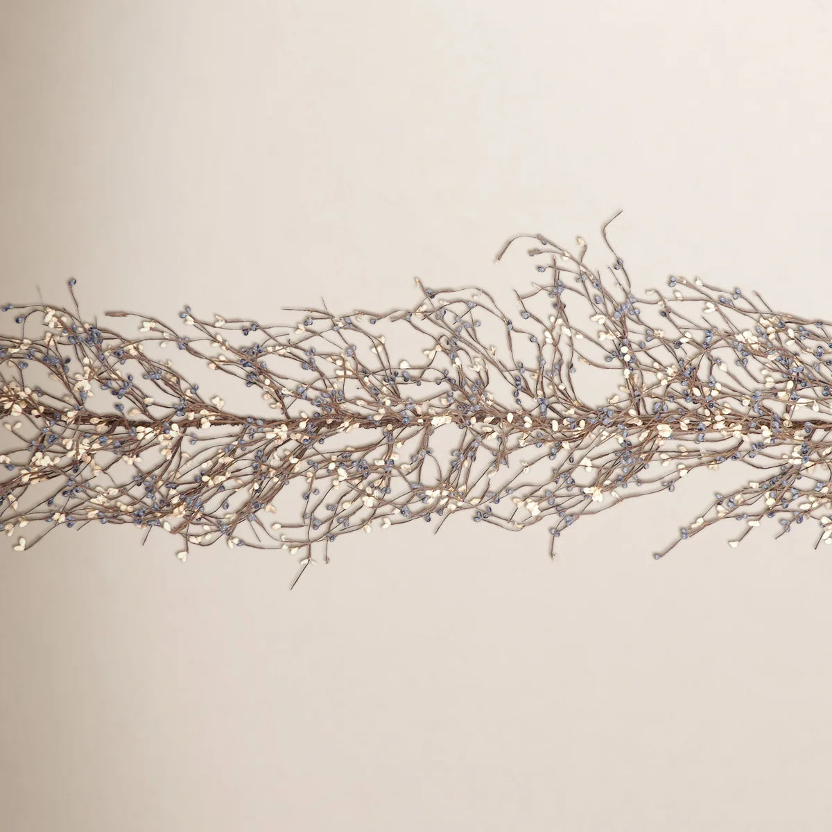 Mini berry twig garland on a warm wall