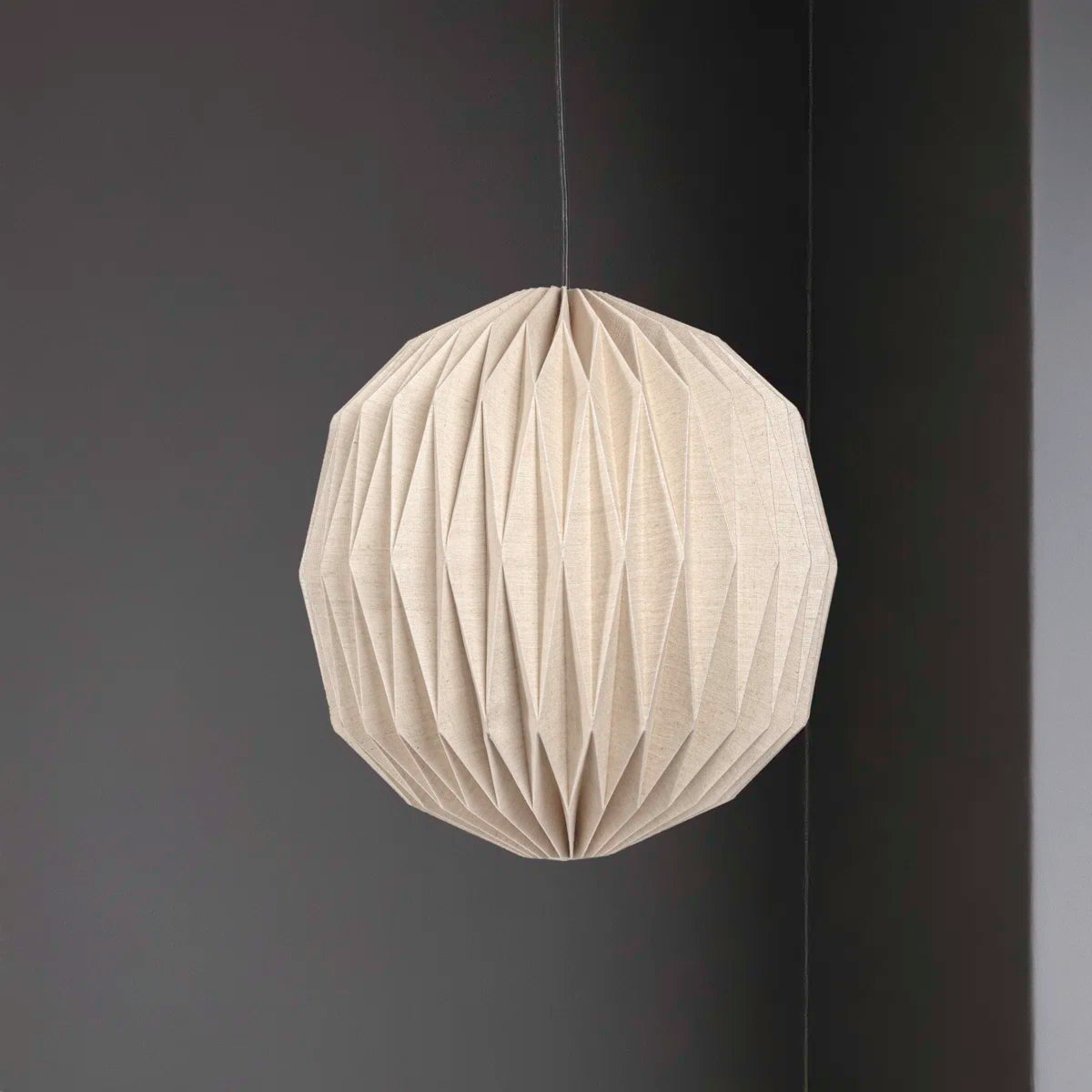 Vaughn honeycomb paper pendant against a dark wall